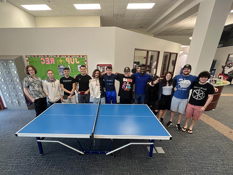 group photo behind a ping pong table